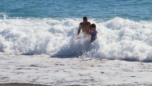 Antalya'da karla kaplı dağların gölgesinde turistlerin deniz keyfi
